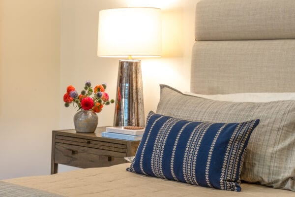 Bed throw pillows and side table with flowers