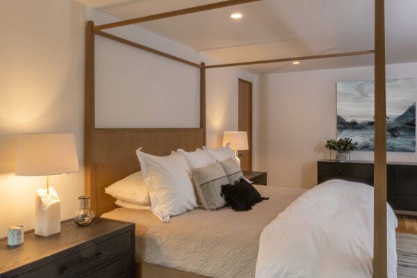 View of a bedroom with four-post bed, side tables with lamps, and dresser