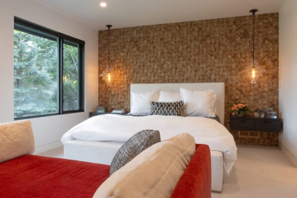 Bedroom with textured wall, hanging side lights over hanging end tables.