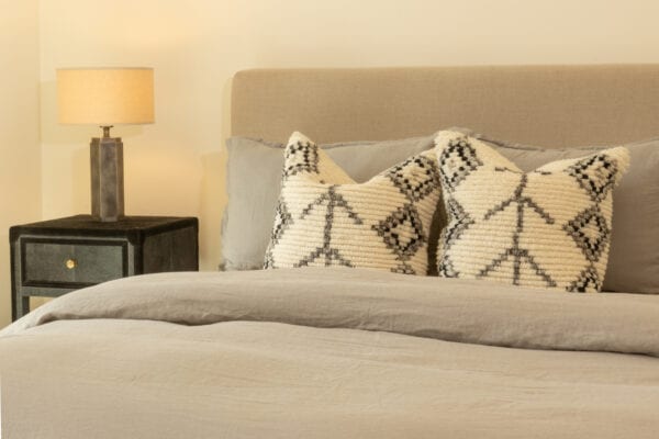 Closeup view of bed with side table and lamp
